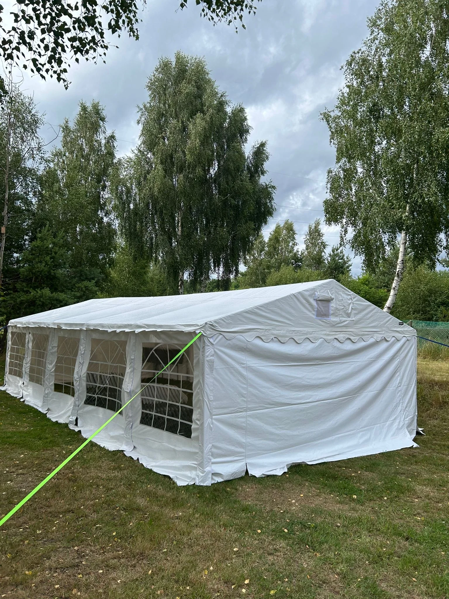 Namiot 6×12m w ogrodzie podczas chmurzystej pogody — plan B na deszcz, brzozy